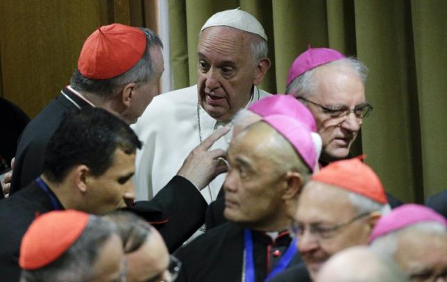Pope Francis talks with cardinals as he leads the synod on the family in the Synod hall at the Vatican